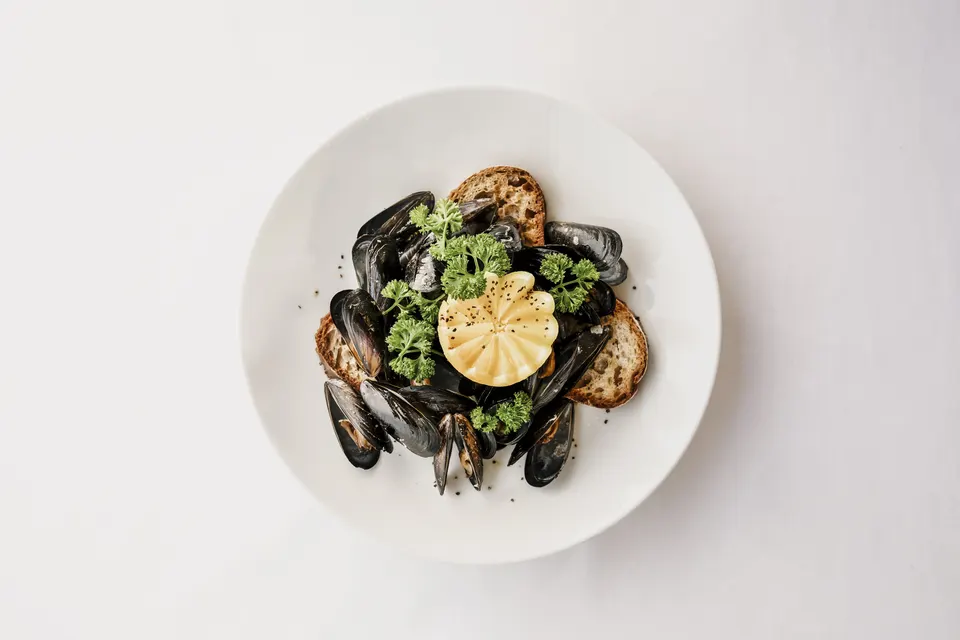 Traditionelles Tessiner Menu Muscheln mit Brot und Zitrone